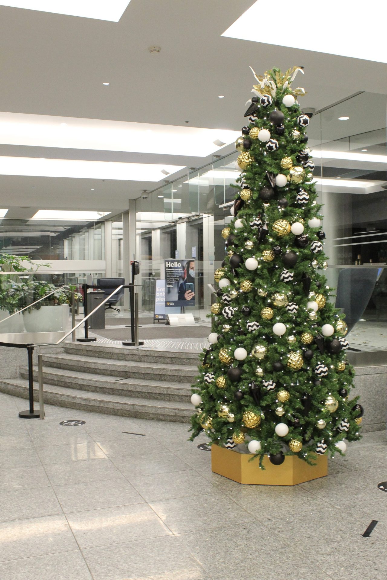 12' tall artificial christmas tree with gold hexagon base decorated in black white and gold decor