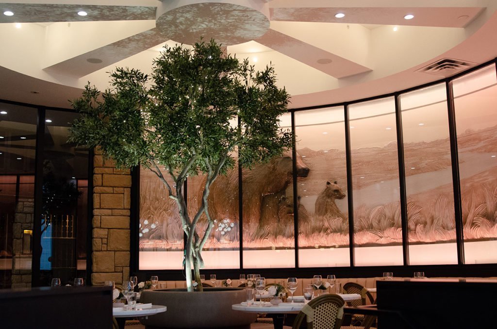 Artificial commercial trees styled in a restaurant interior.