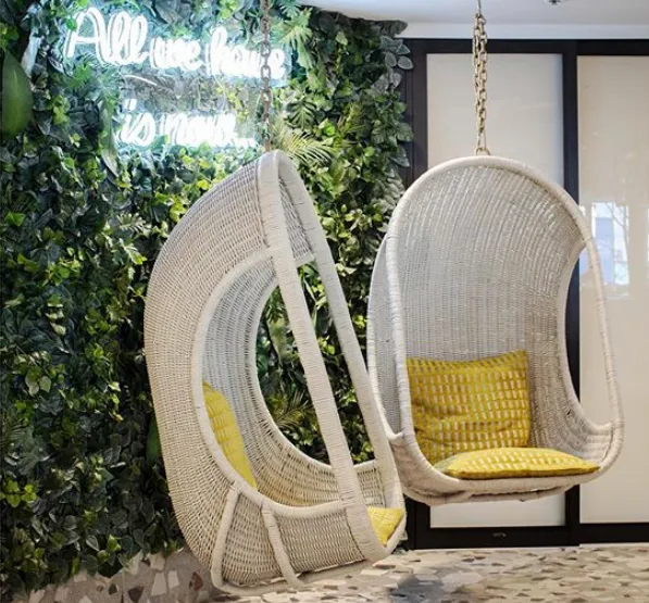 Custom green wall made from high quality materials creates lush backdrop for hanging chairs