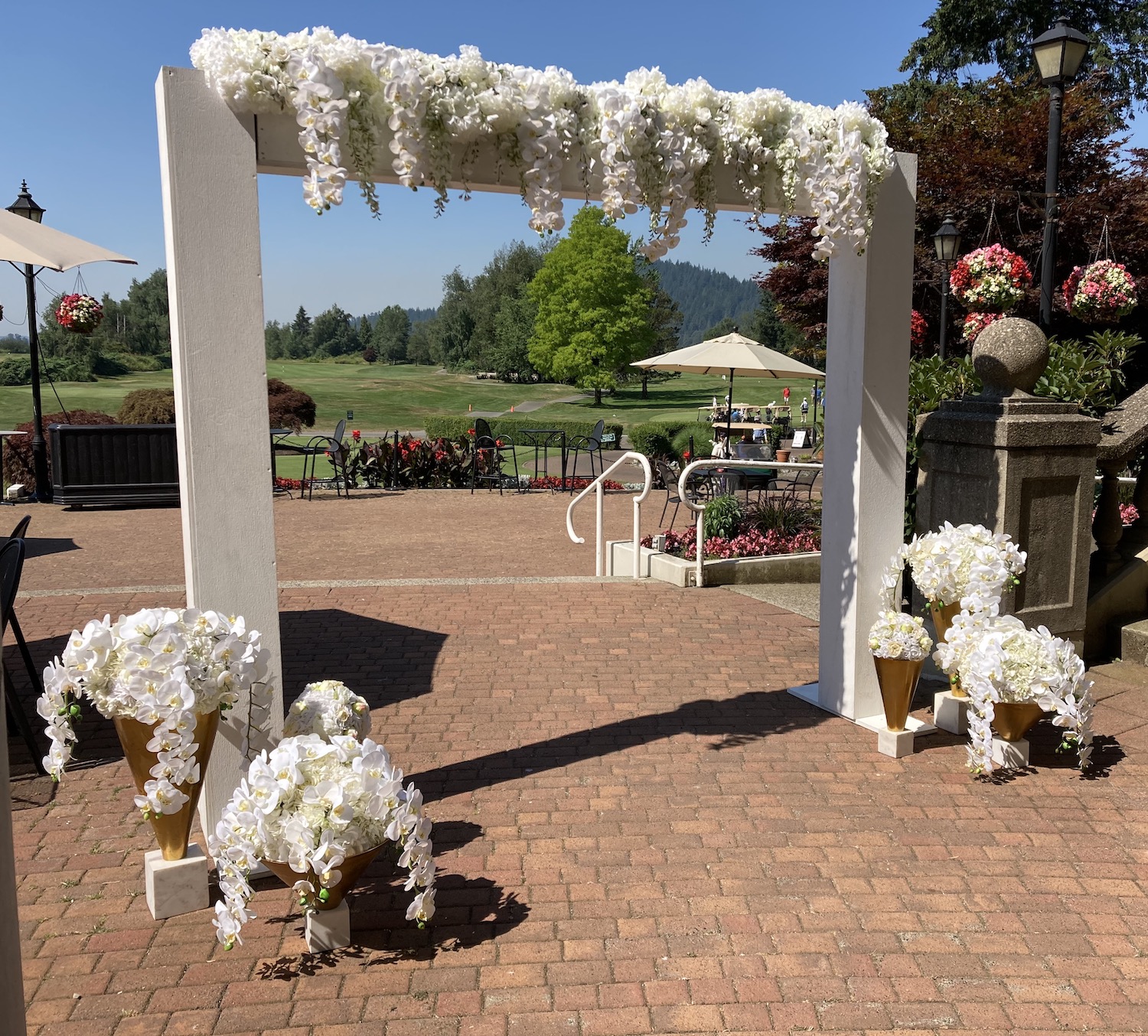 white wooden wedding archway decorated in white florals