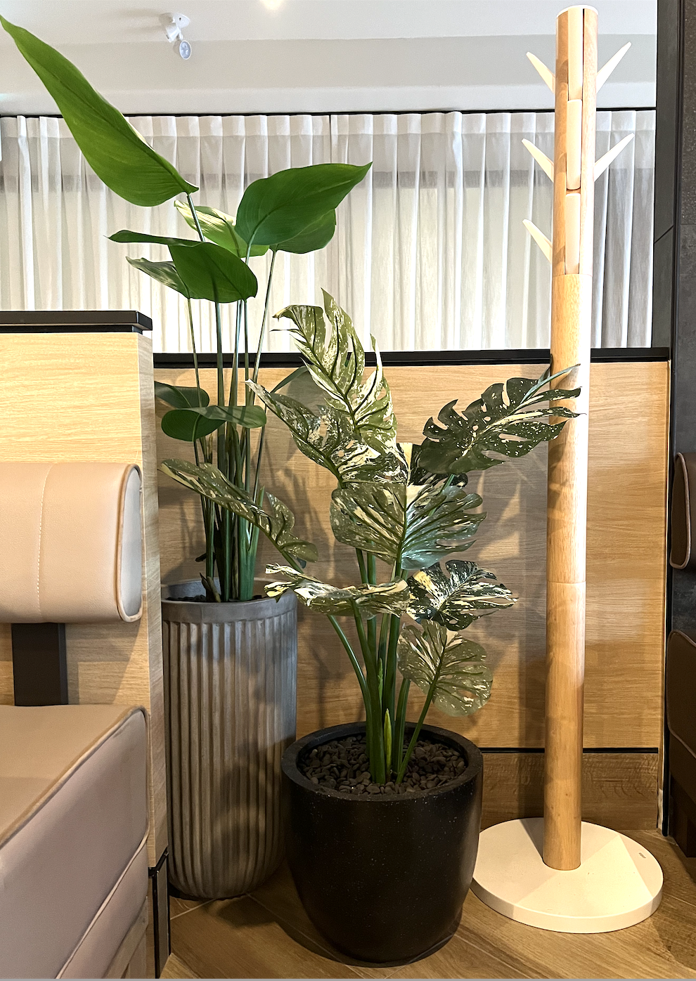 Vibrant artificial tropical plants in planters adorn the restaurant, adding a touch of exotic greenery.