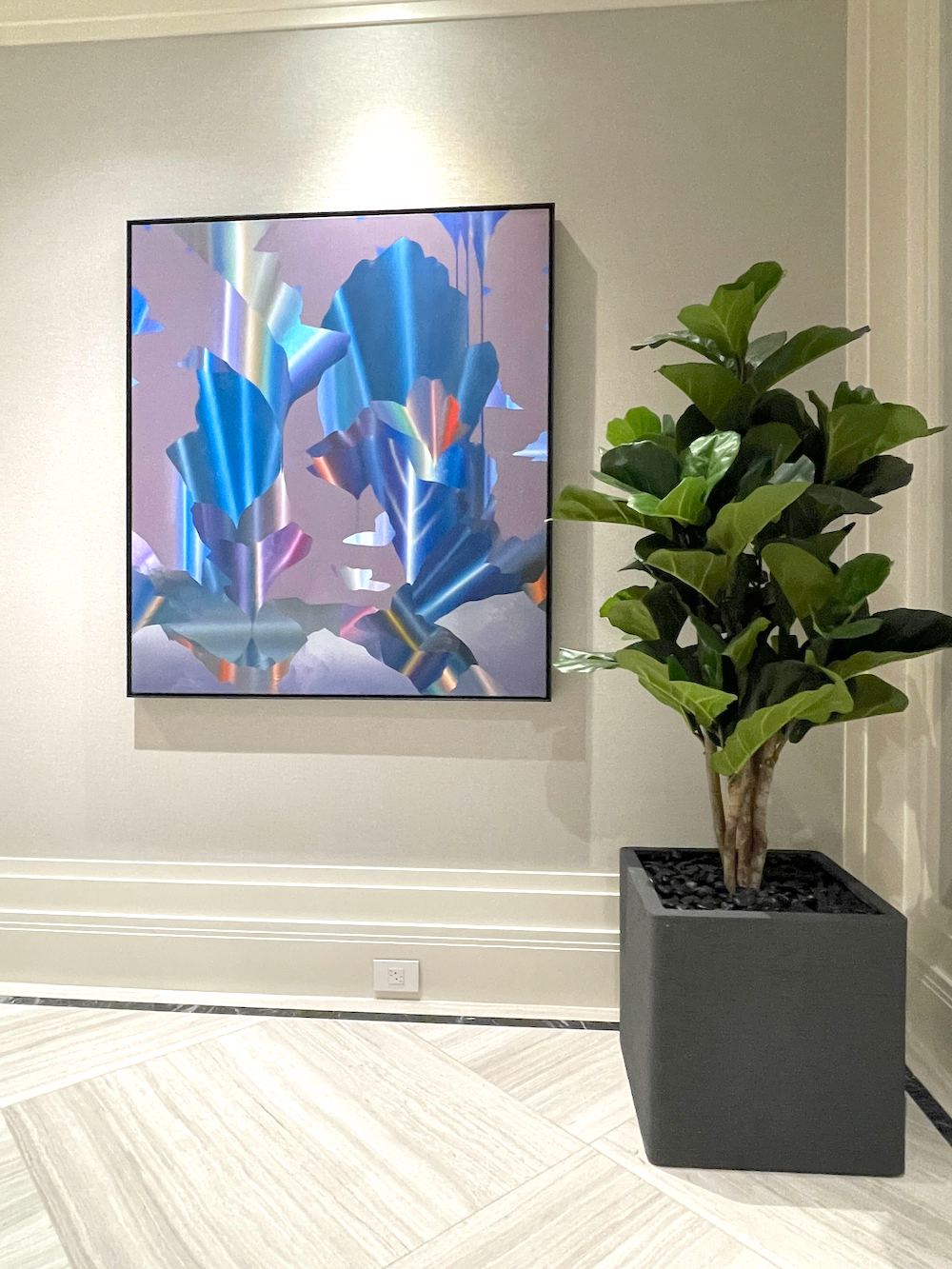 Artificial fiddle leaf fig plant in a square planter in a home corner next to a painting