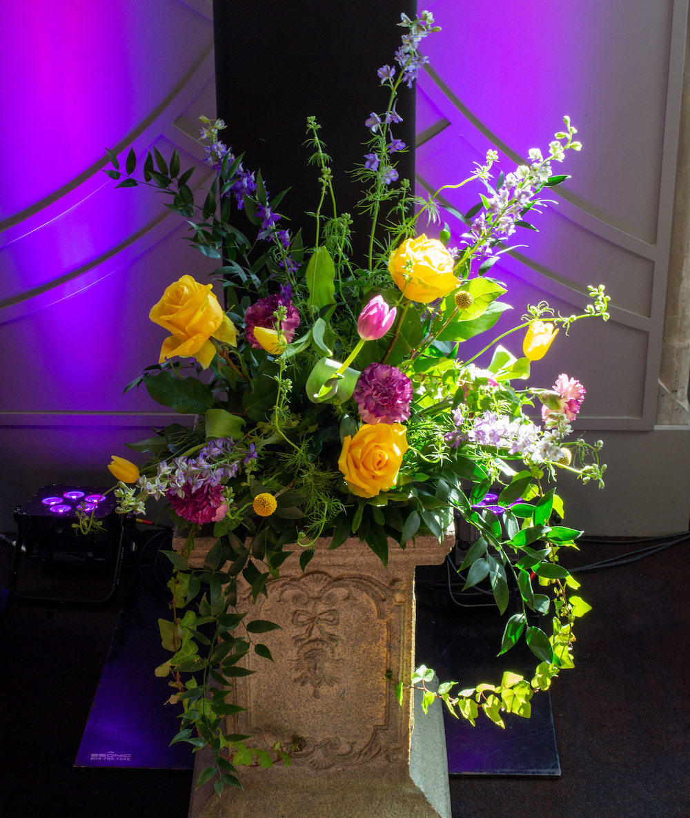 Vibrant colorful floral arrangement on a pedestal.