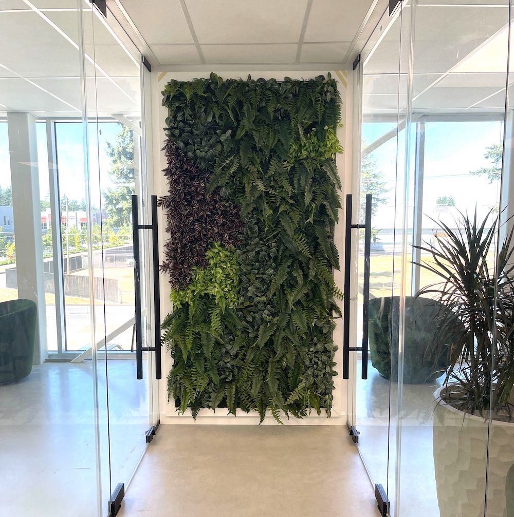 Artificial IFR greenery by Greenscape Design on a green wall in a Vancouver office space.