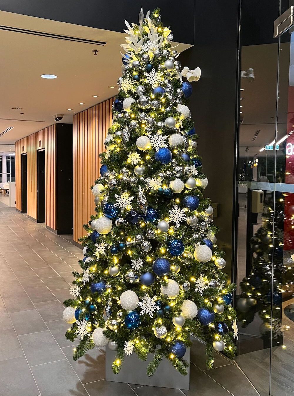 Blue, white, and silver Christmas tree rental by Greenscape Design for commercial spaces in Vancouver.