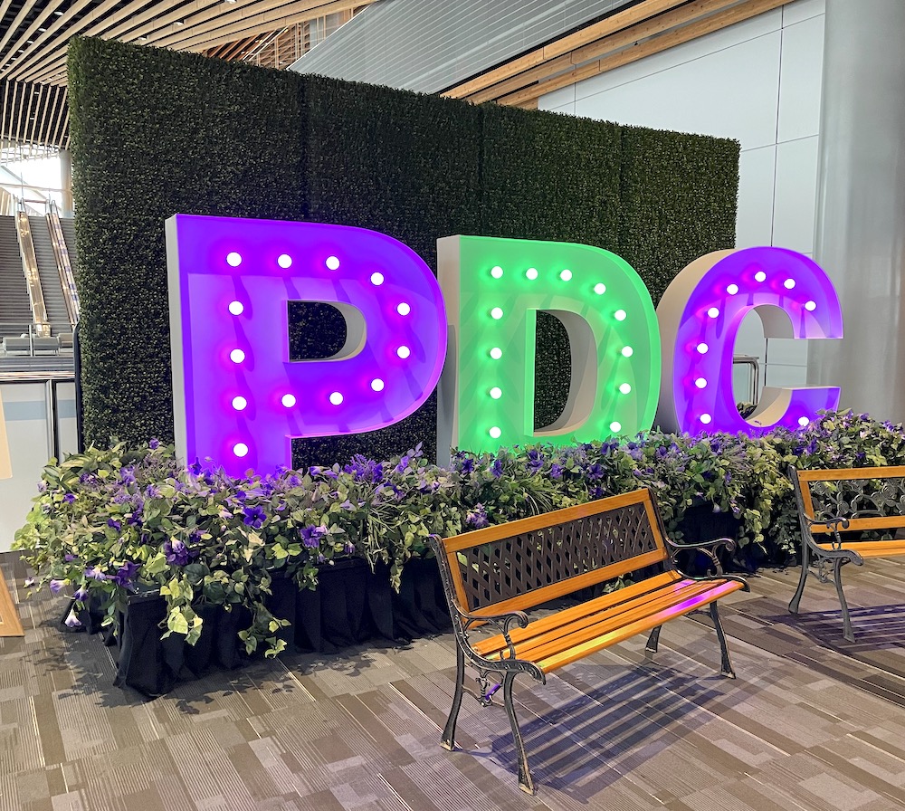Branded photo op with Greenscape Design's boxwood hedge backdrop, base gardens, and park benches rentals in Vancouver.