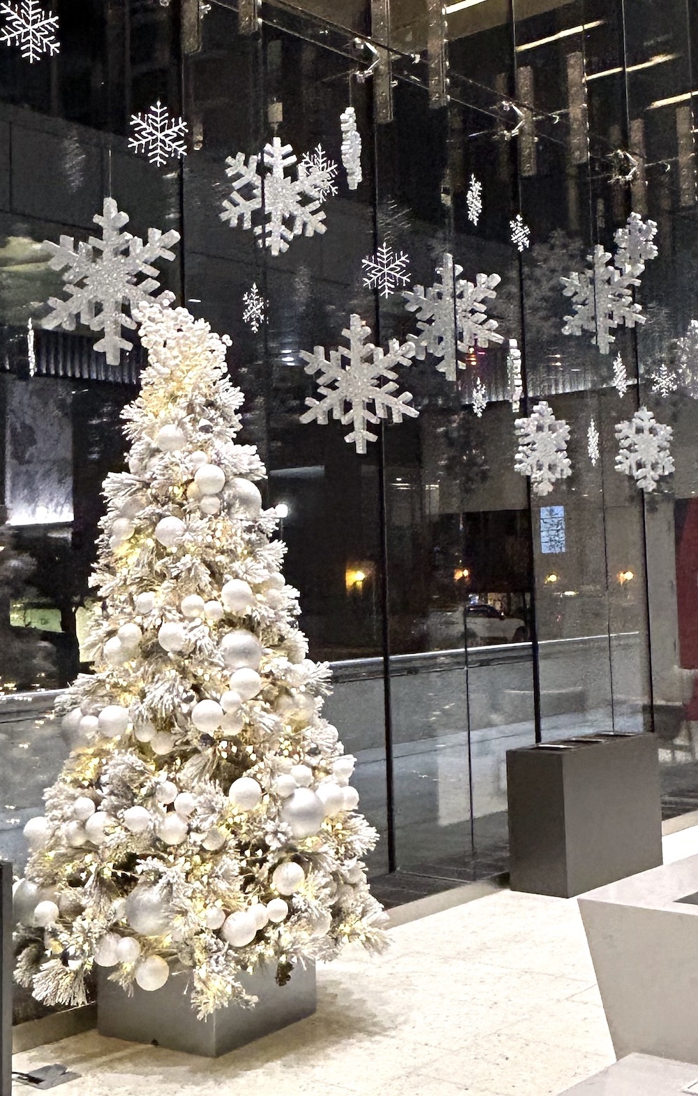 Greenscape Design's custom flocked Christmas tree and snowflake window display create a winter wonderland ambiance in The Stack, Vancouver's newest office space.