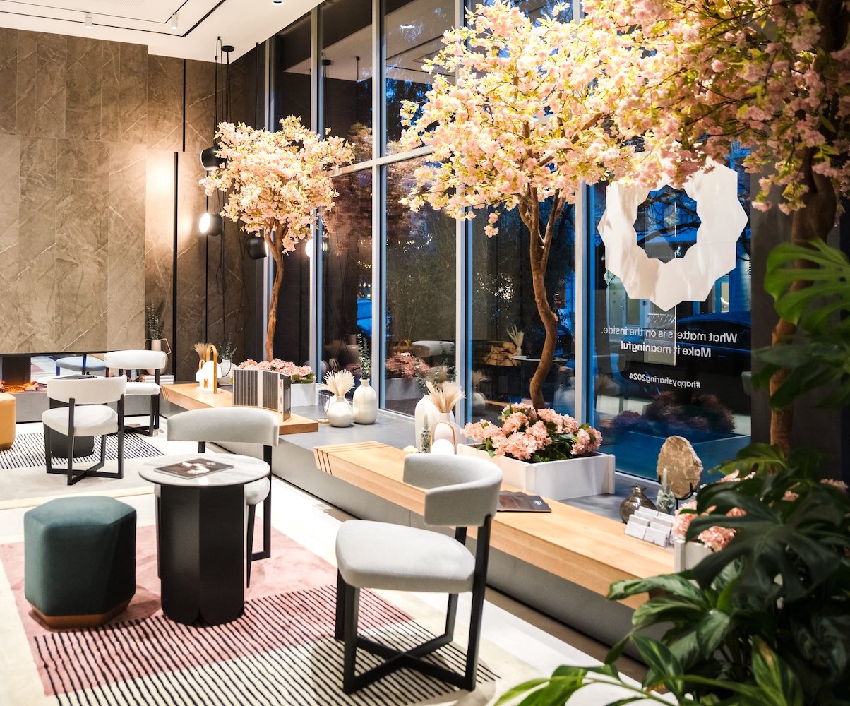 Event decor by Greenscape Design with cherry blossom trees interspersed in the seating area.