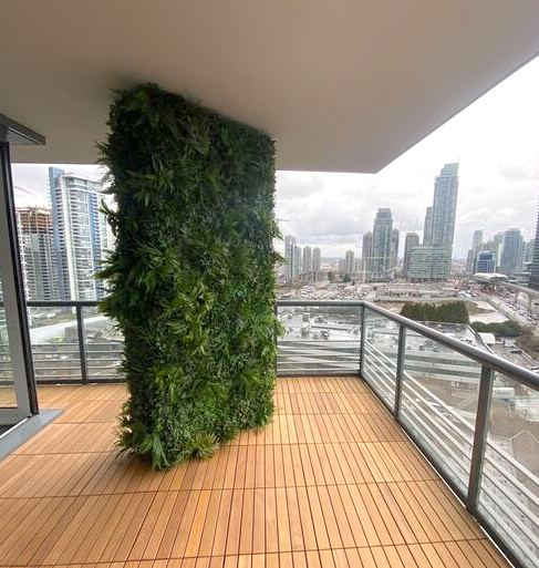 Condo patio with artificial green wall feature decor piece