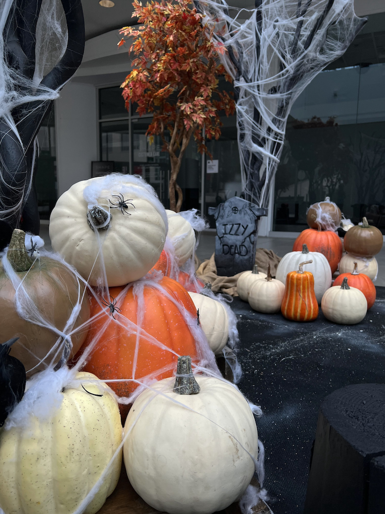 Artificial gold, white, and orange pumpkins with tall red maple tree, creating a haunted forest ambiance in Greenscape Design's Halloween decor rental at Lougheed Town Centre, Vancouver.