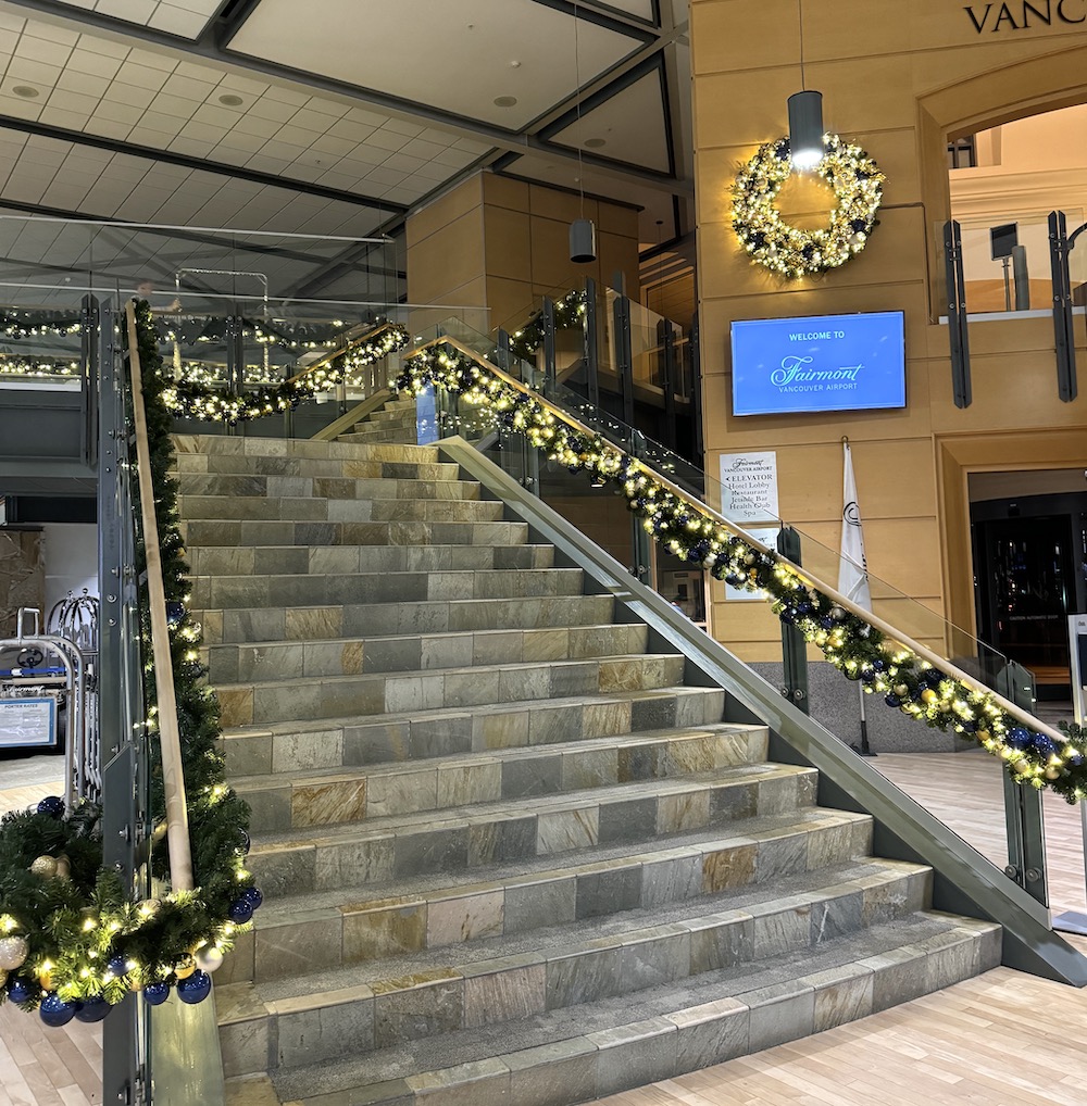 Vibrant holiday wreaths and garlands adorn the Fairmont Airport Hotel in Vancouver, designed and installed by Greenscape Design for a festive atmosphere.
