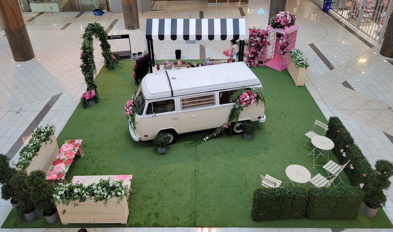 Florals adorn a Volkswagen bus and phone booth, creating a fun interactive photo op at Guildford Centre's spring event.