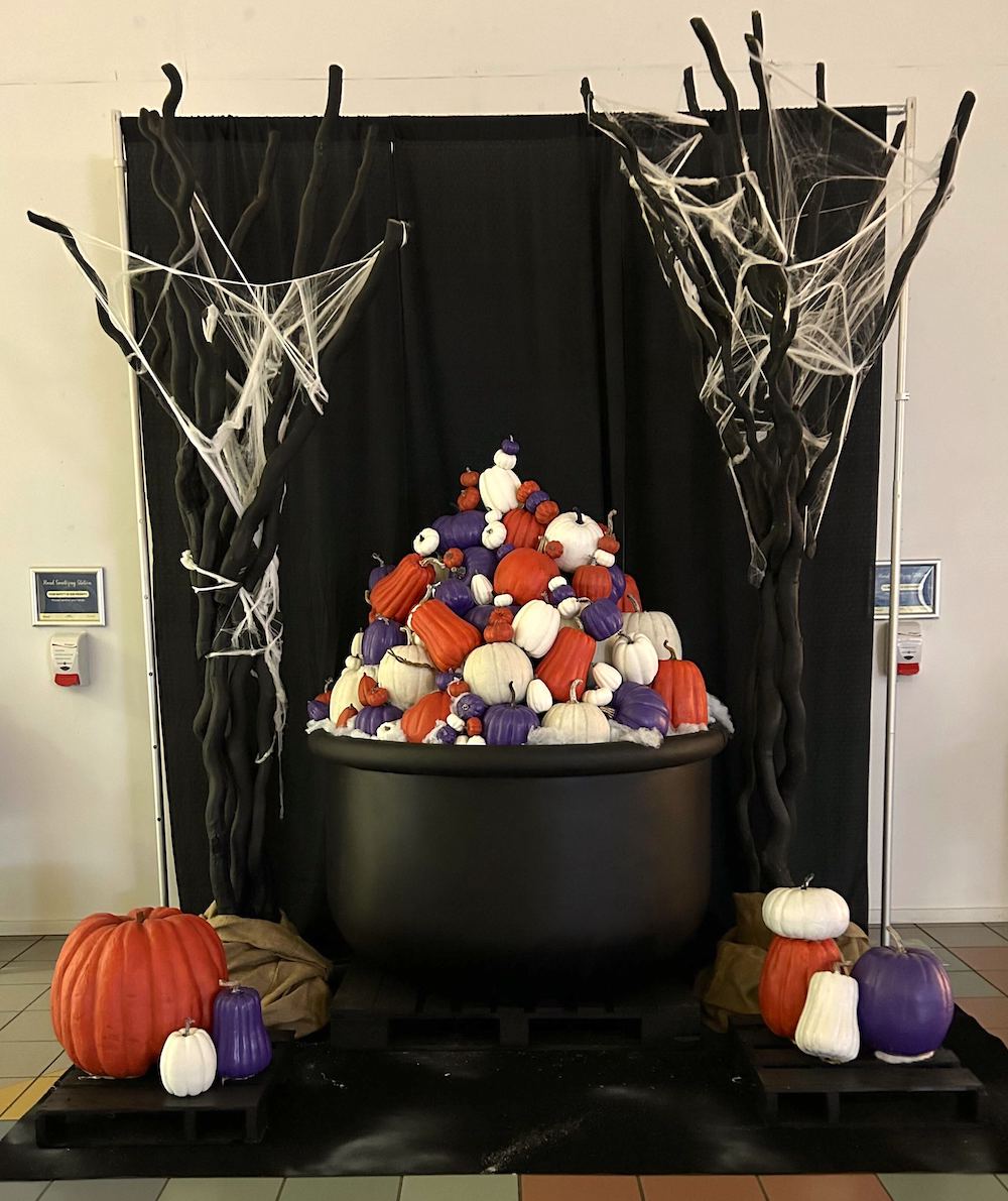 Oversize black cauldron filled with purple, orange, and white pumpkins, creating a larger-than-life photo op at Sevenoaks Shopping Centre.