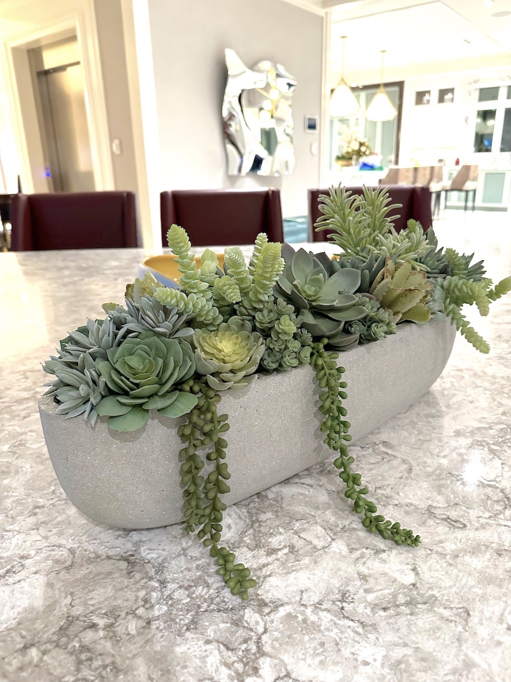 artificial succulents in a table top planter in a residential kitchen area