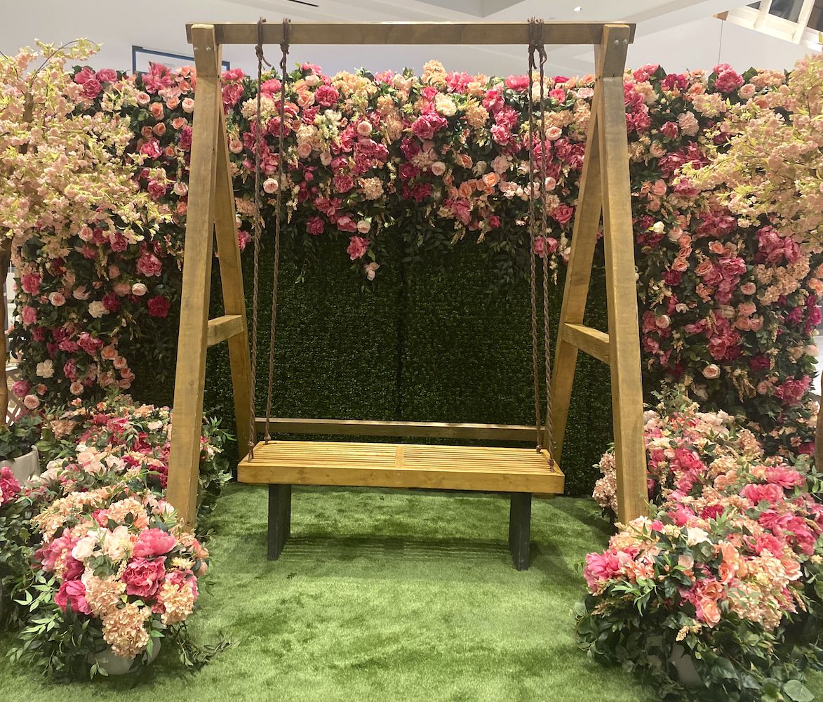Greenscape Design's Easter display at Willowbrook Shopping Centre features a whimsical swing set against a backdrop of vibrant florals, offering a delightful photo opportunity.