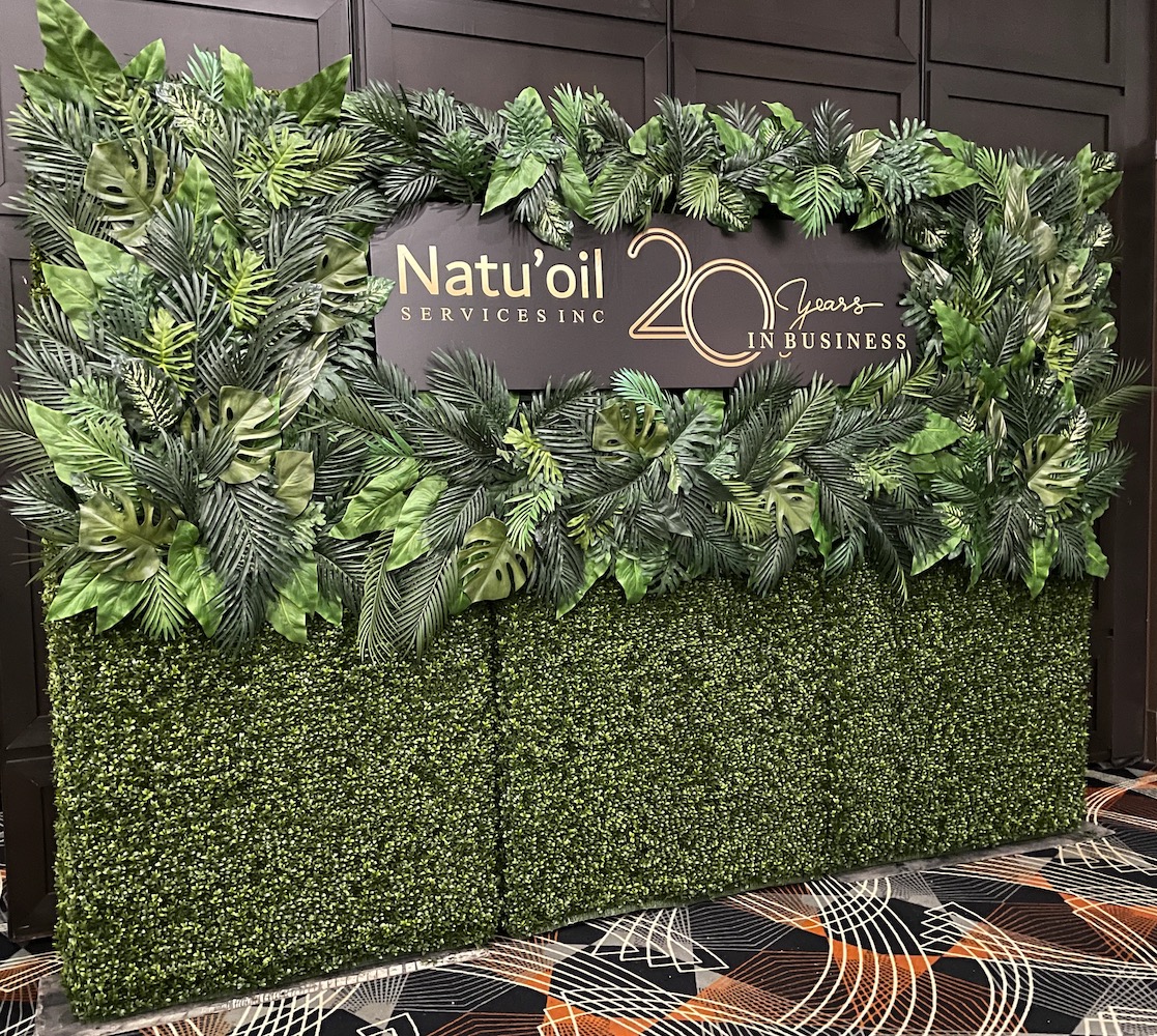 Tropical greenery on a Boxwood Hedge with custom branded signage by Greenscape Design.