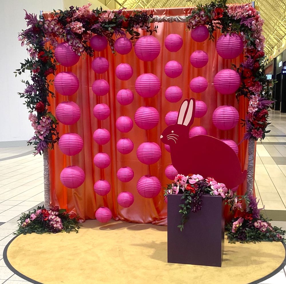 Greenscape Design's Year of The Rabbit Lunar New Year backdrop at Coquitlam Centre featuring pink lanterns, floral arrangements, and a red bunny.