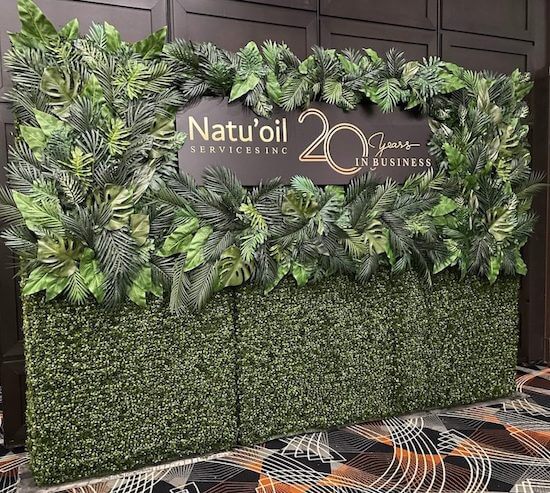 custom green wall with branded client name for corporate event decor by Greenscape Design