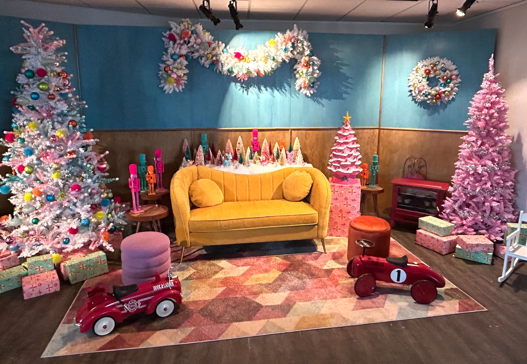 Retro-themed Christmas decor by Greenscape Design at Banff Gondola featuring pastel-colored trees, a yellow sofa, and vintage toy accents.
