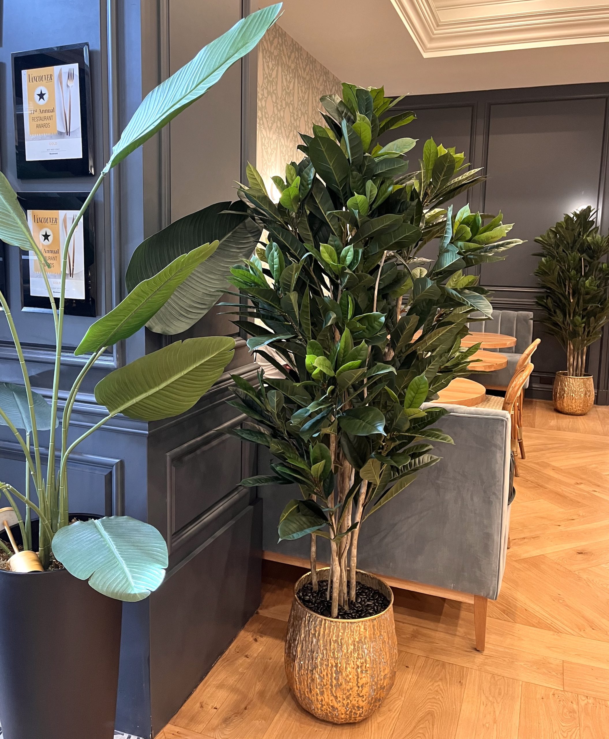 Artificial potted plants in decorative containers enhancing the ambiance of a luxury hotel lobby space.