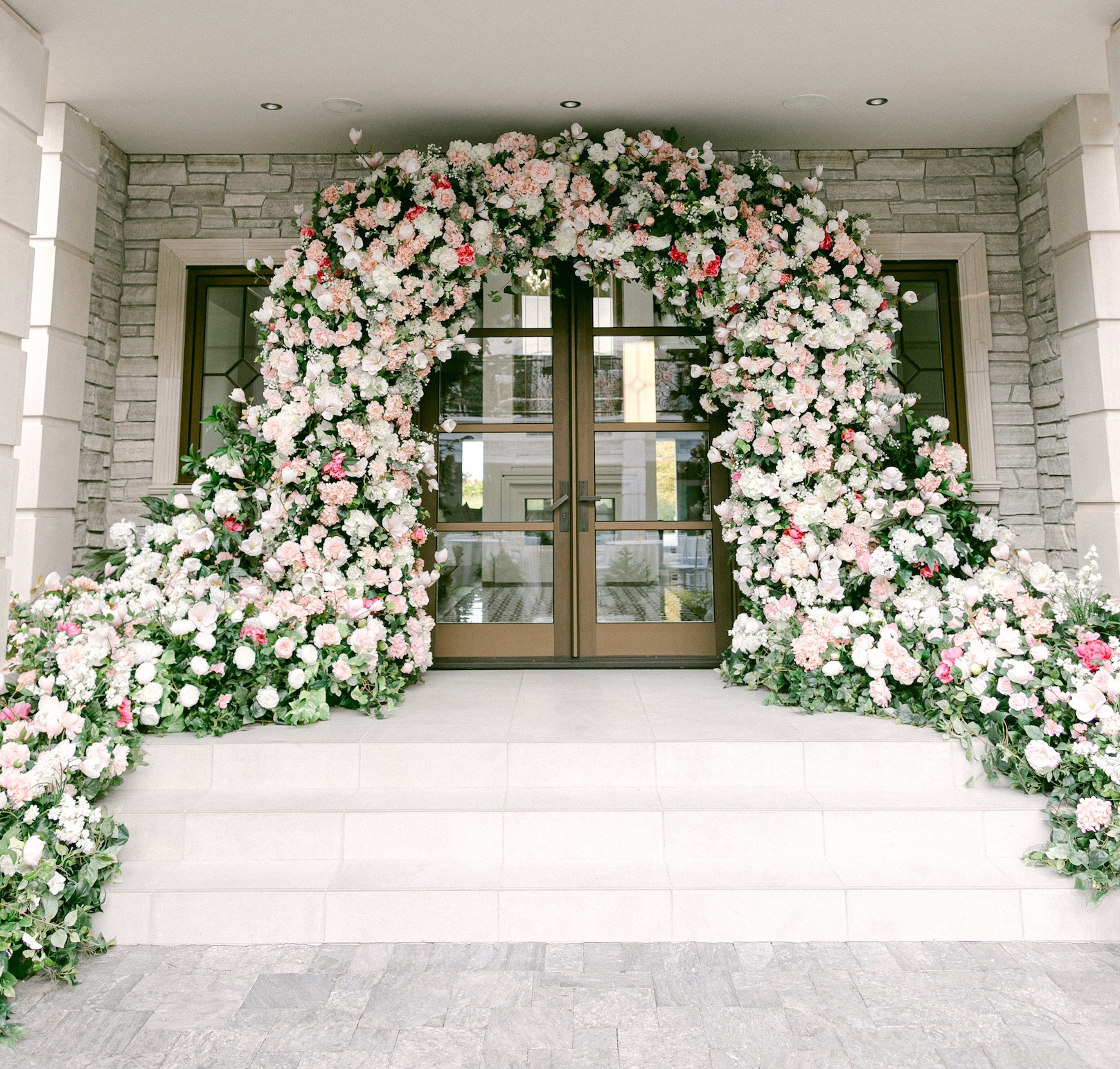 Luxurious artificial floral arch in soft pink and white hues, framing an elegant entrance for a wedding venue in Vancouver.