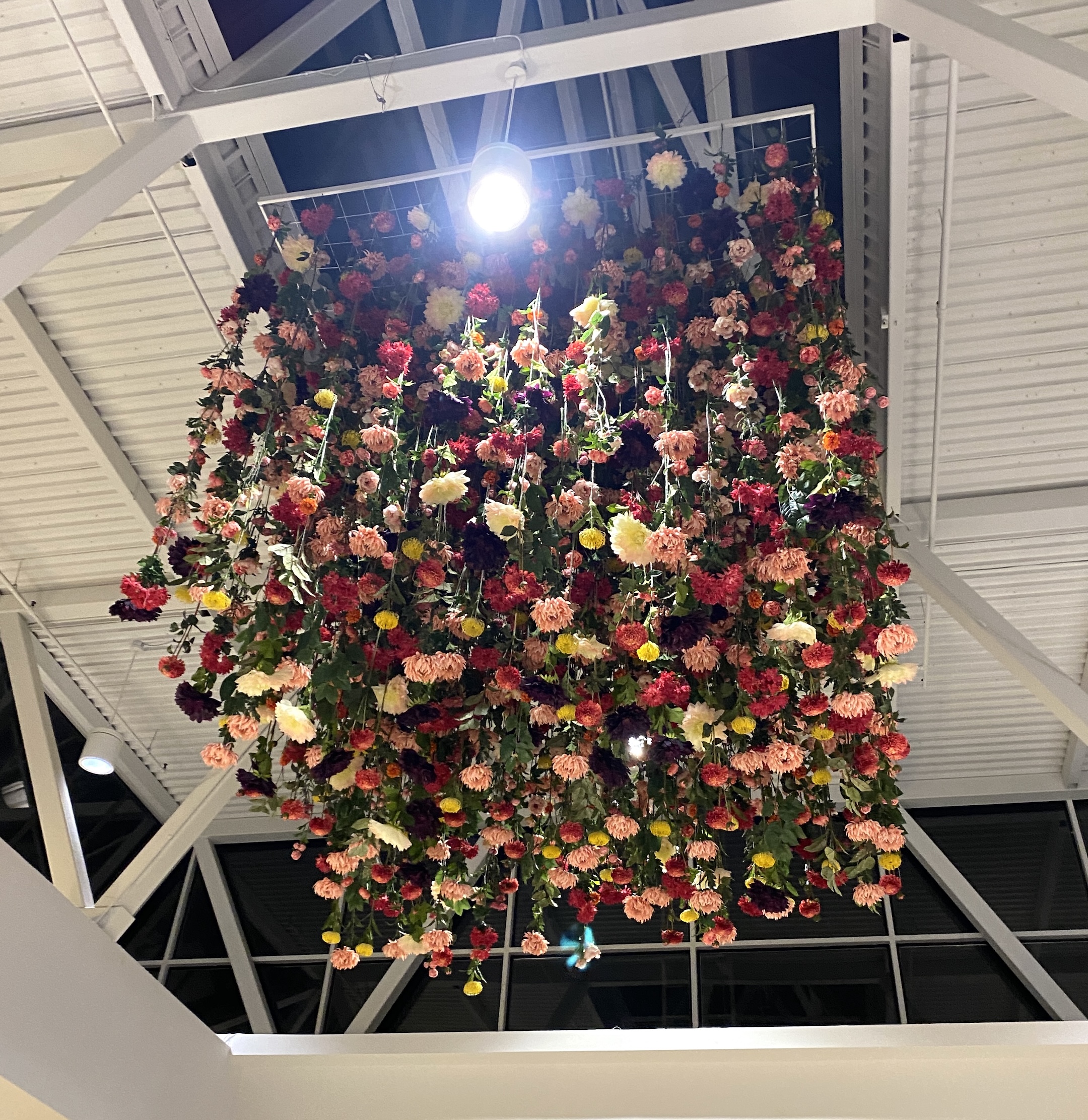 Hanging floral ceiling installation with colorful seasonal blooms, creating a vibrant and eye-catching display in Guildford Shopping Centre.