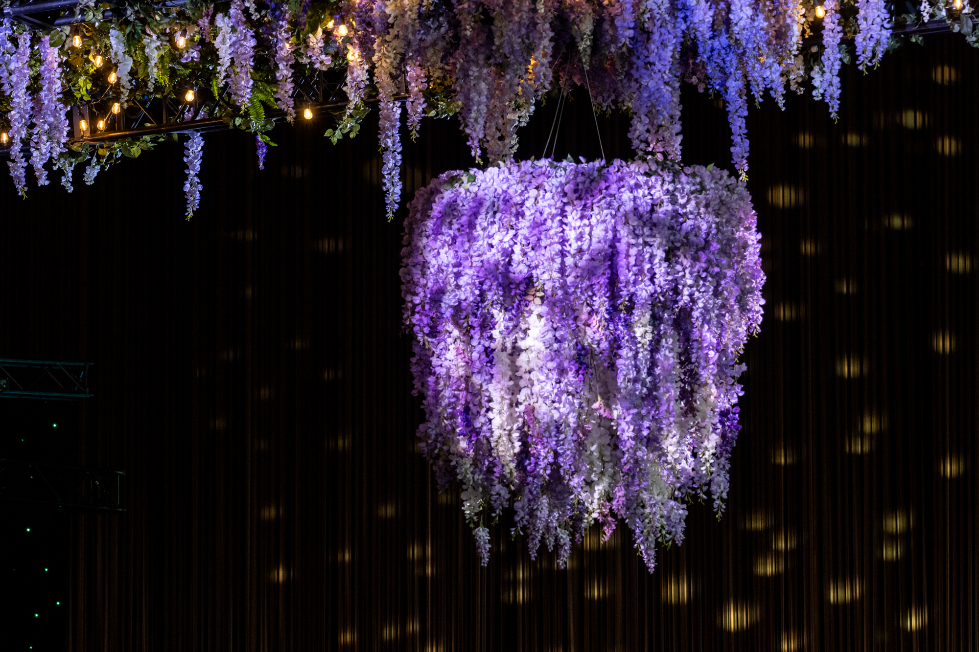 A luxurious event space featuring a cascading faux wisteria chandelier, creating an elegant and romantic atmosphere.