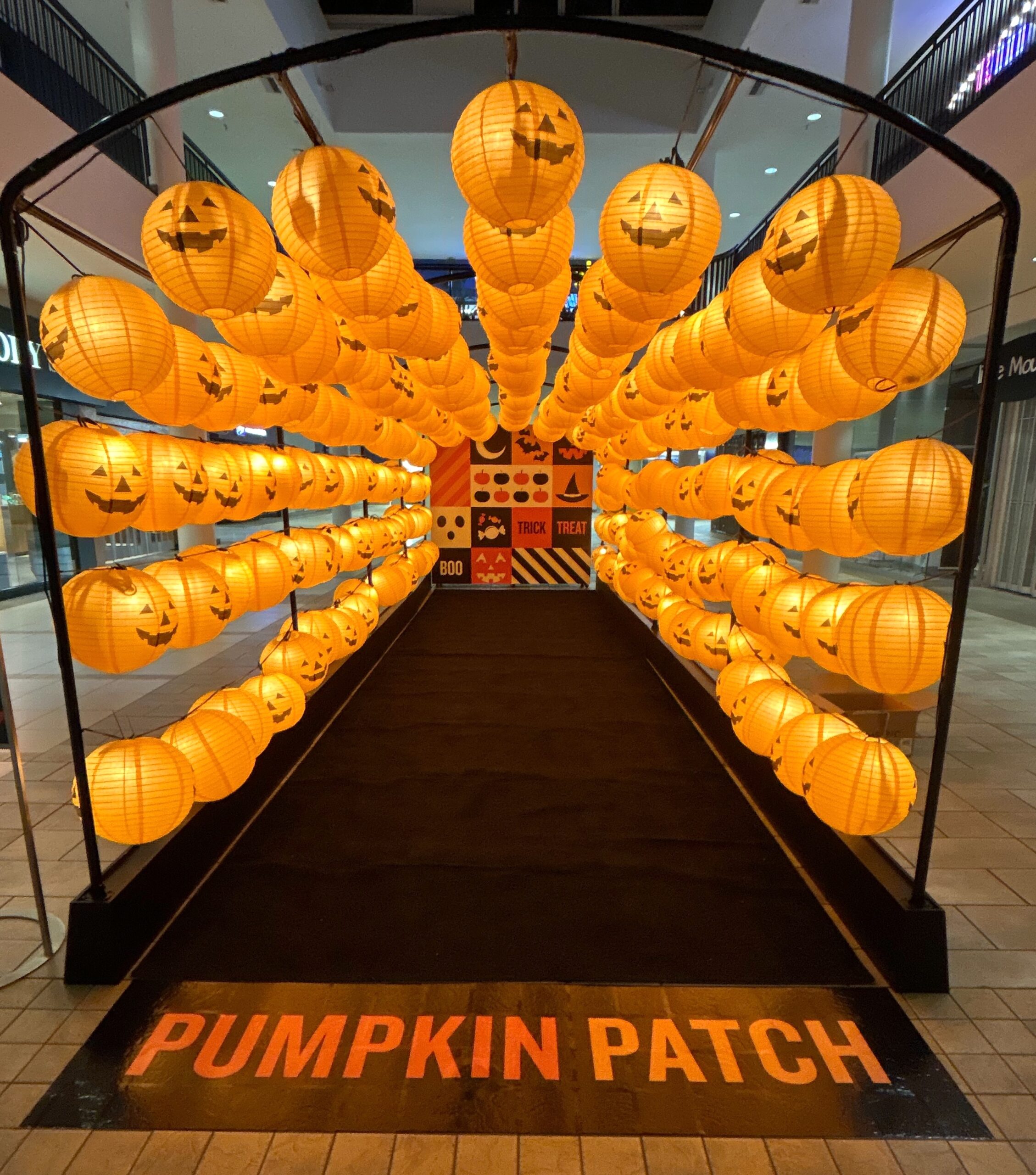Custom Halloween lantern tunnel featuring glowing jack-o'-lanterns at a shopping center display in Vancouver.