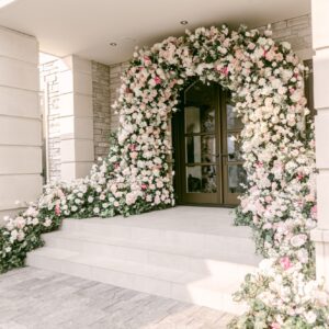 Custom floral arch design and installation with cascading artificial blooms in soft pinks and whites by Greenscape Design.