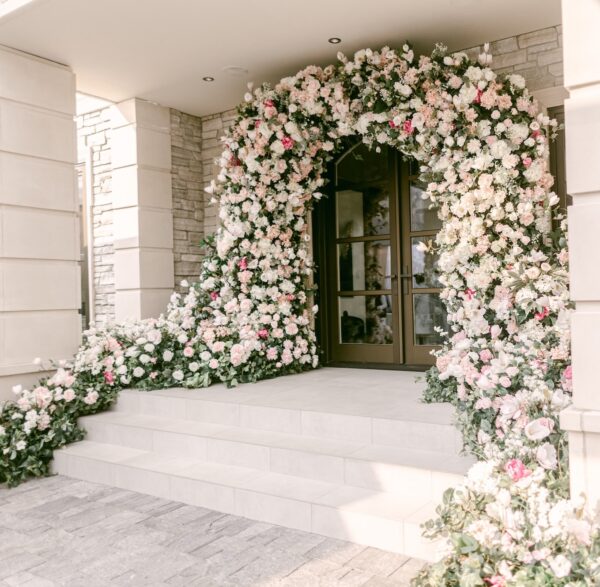 Custom floral arch design and installation with cascading artificial blooms in soft pinks and whites by Greenscape Design.
