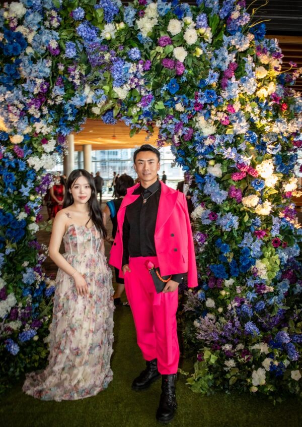 Vivid artificial floral arch in blue, purple, and ivory tones, styled for a corporate gala entrance display.