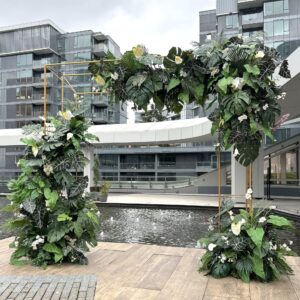 Tropical floral arch with lush greenery and white flowers, perfect for weddings and events in Vancouver.