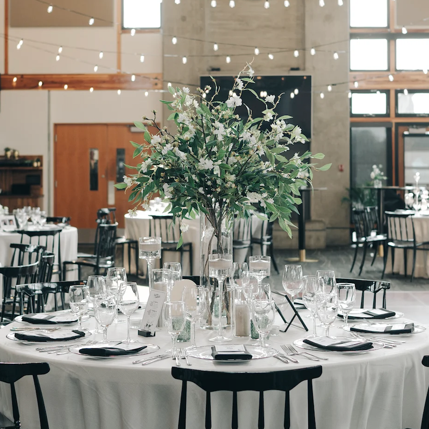 Minimalist wedding table with white florals and greenery centerpiece