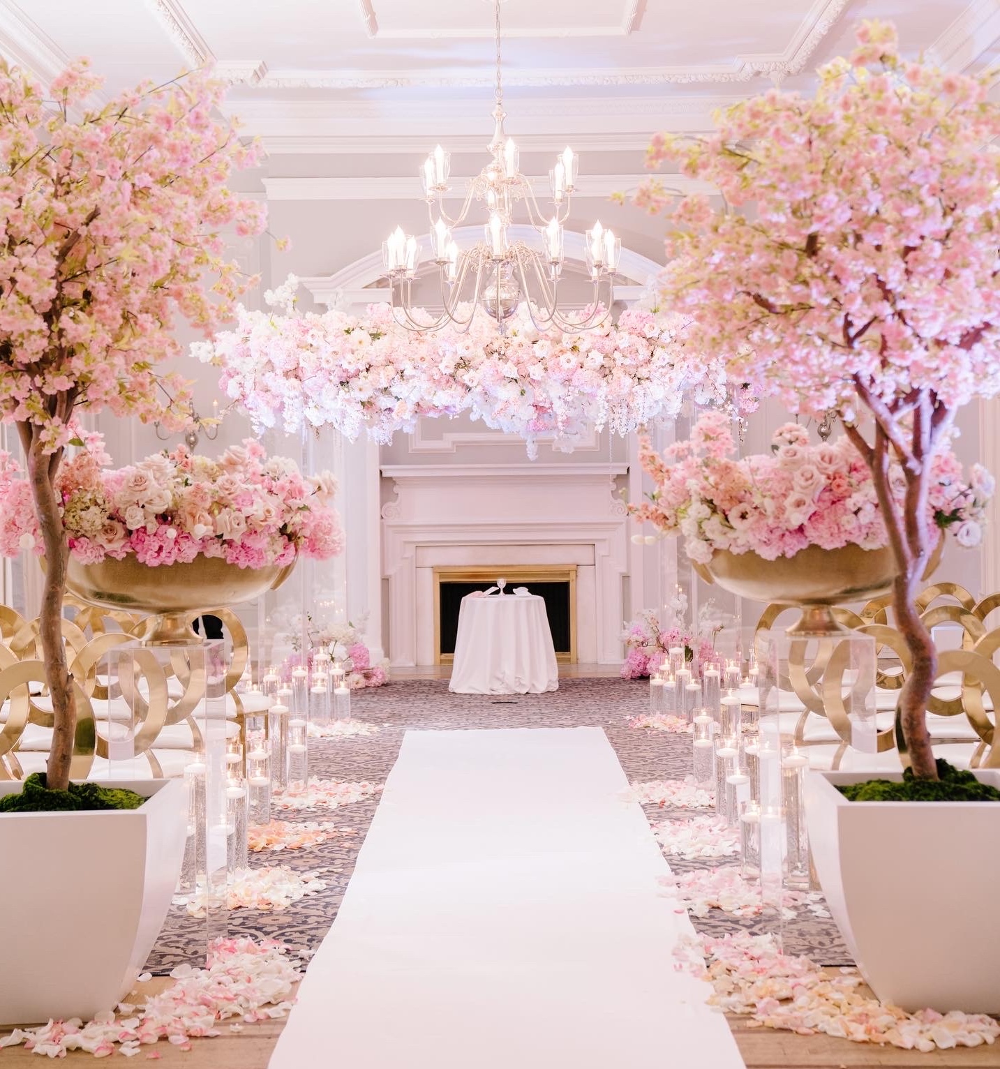 Wedding ceremony with pink cherry blossom trees lining the aisle