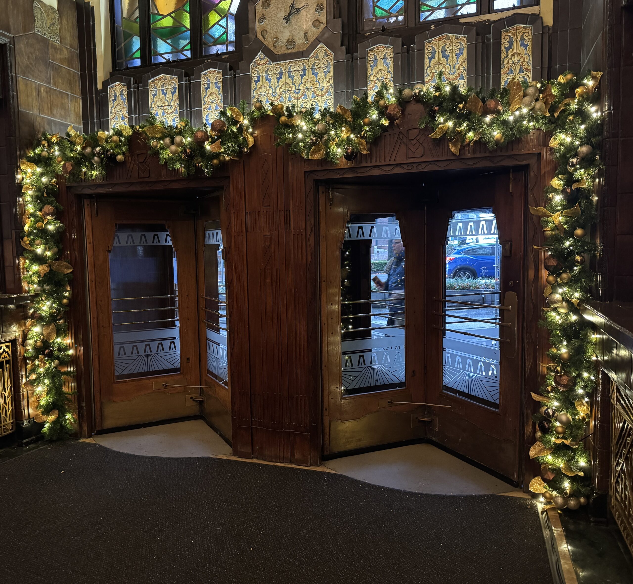 Christmas garland framing heritage building entrance doorway.