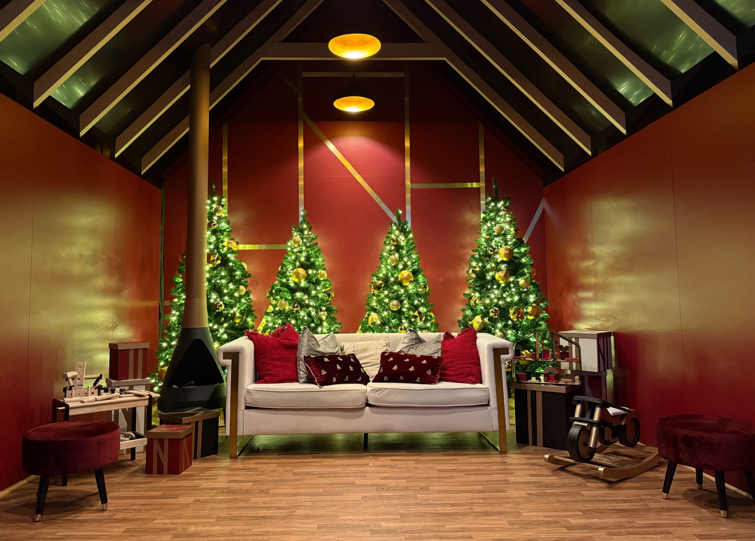 Santa photo set with illuminated Christmas trees, festive décor, and cozy seating arranged in a holiday-themed shopping centre display.