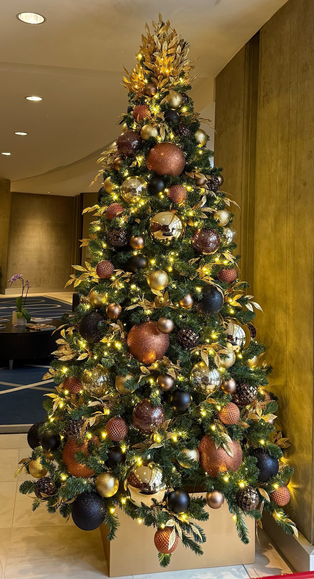 Artificial Christmas tree installed in office lobby corner for holiday décor