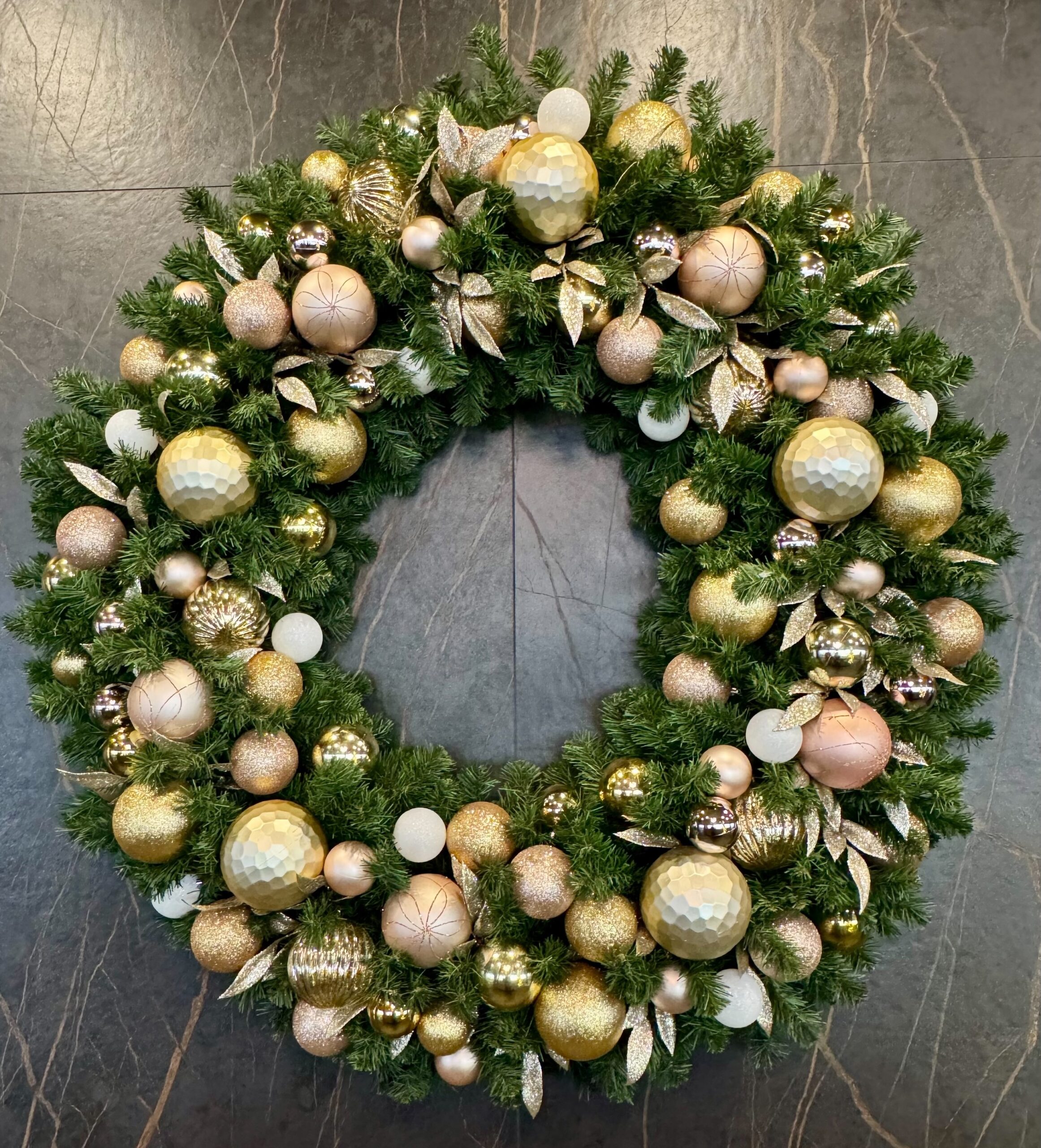 Large Christmas wreath mounted on office lobby wall