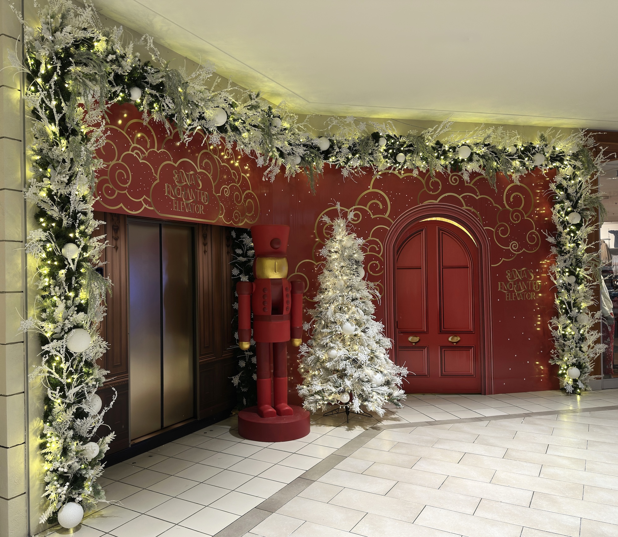 Elevator entrance framed with garland and Christmas décor in mall