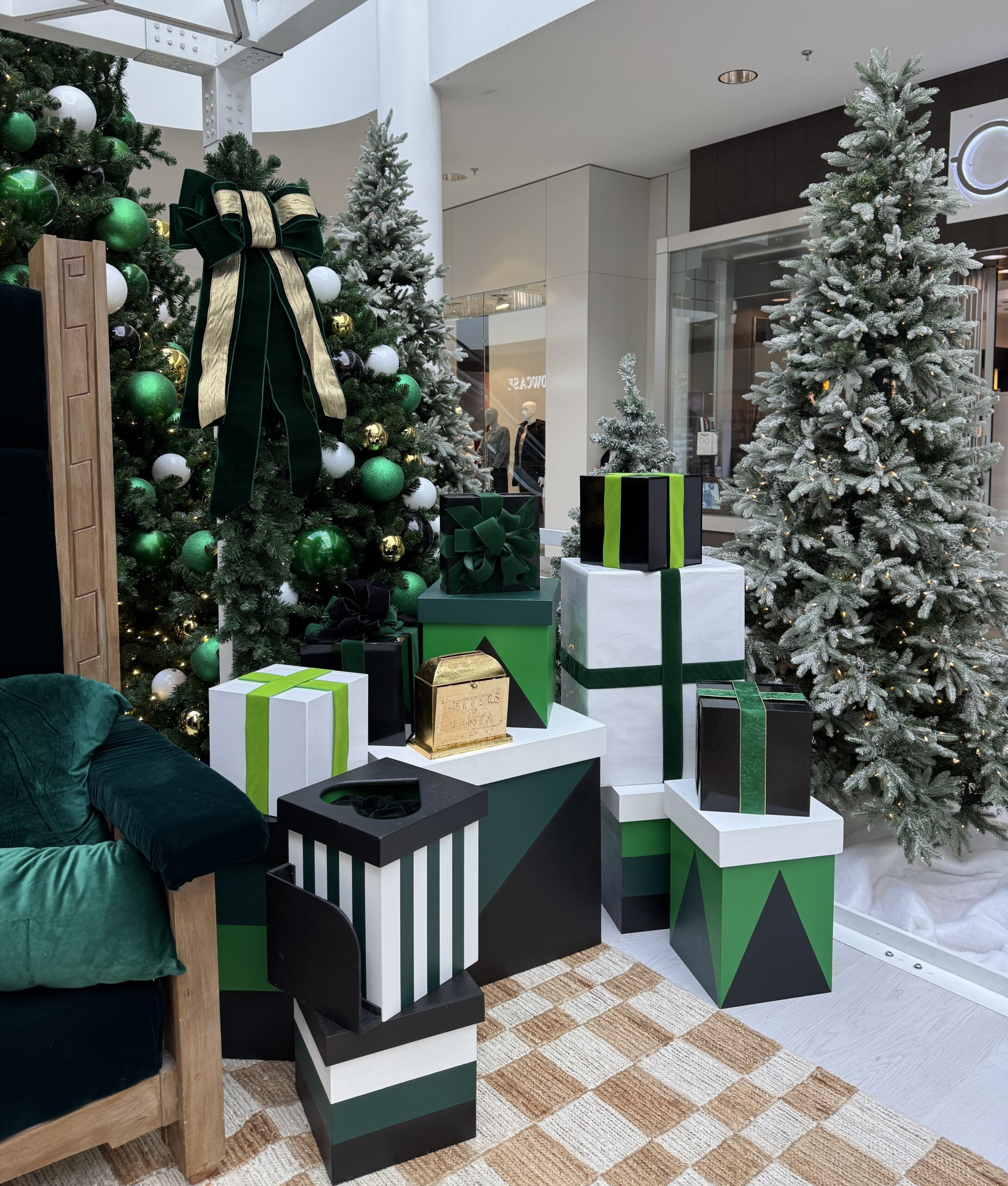 Santa photo area with green arch, Christmas tree, and stacked gift boxes