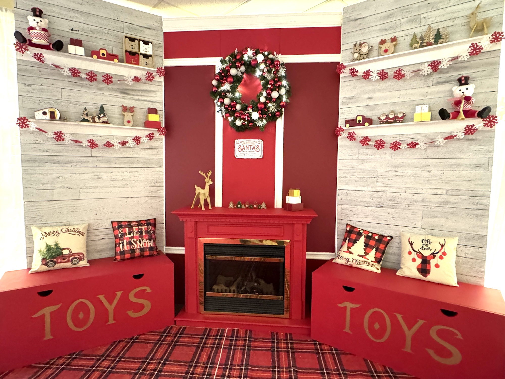Santa workshop Christmas display with toy wall and wreath backdrop