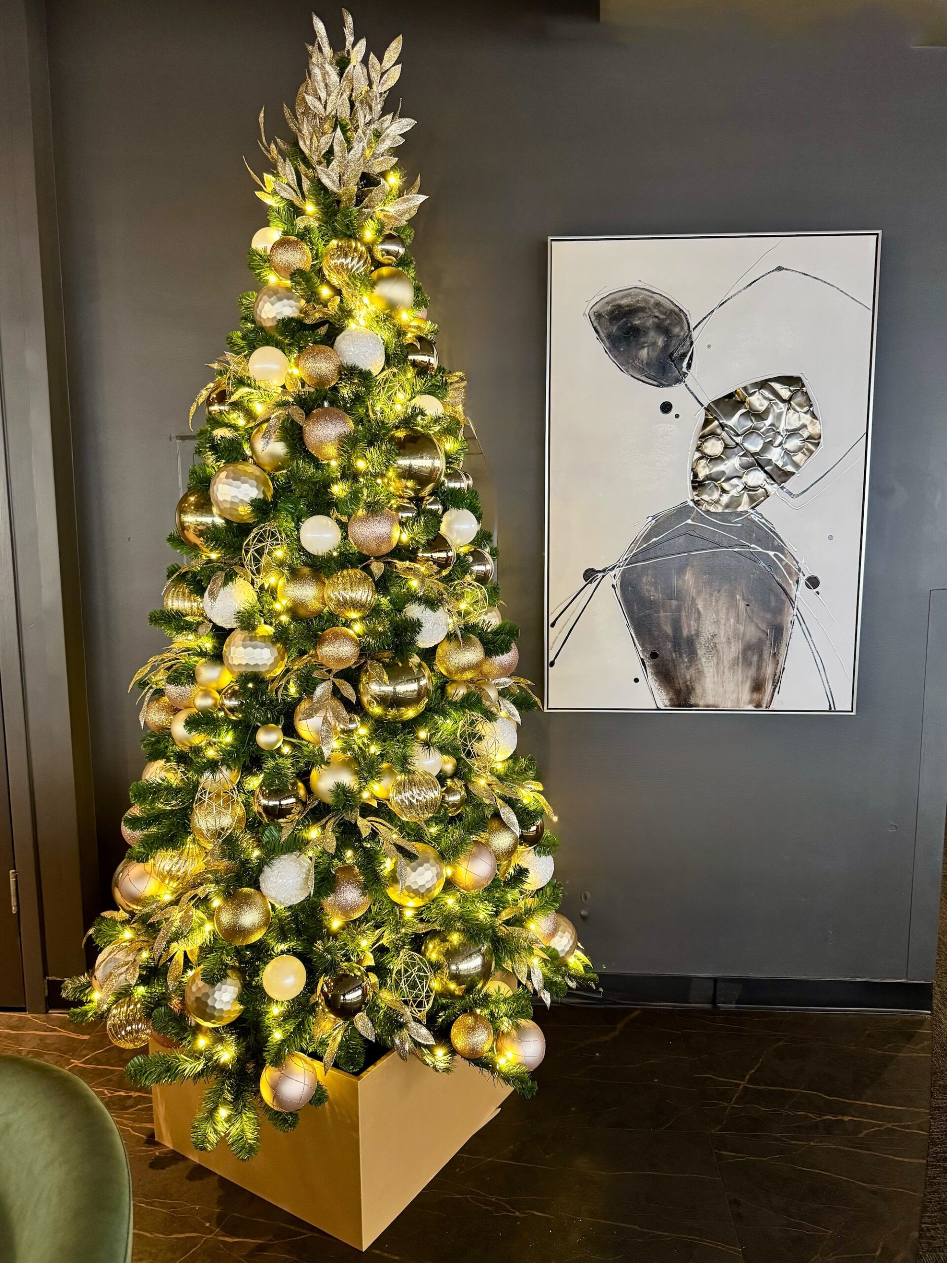 Metallic themed faux Christmas tree in modern interior
