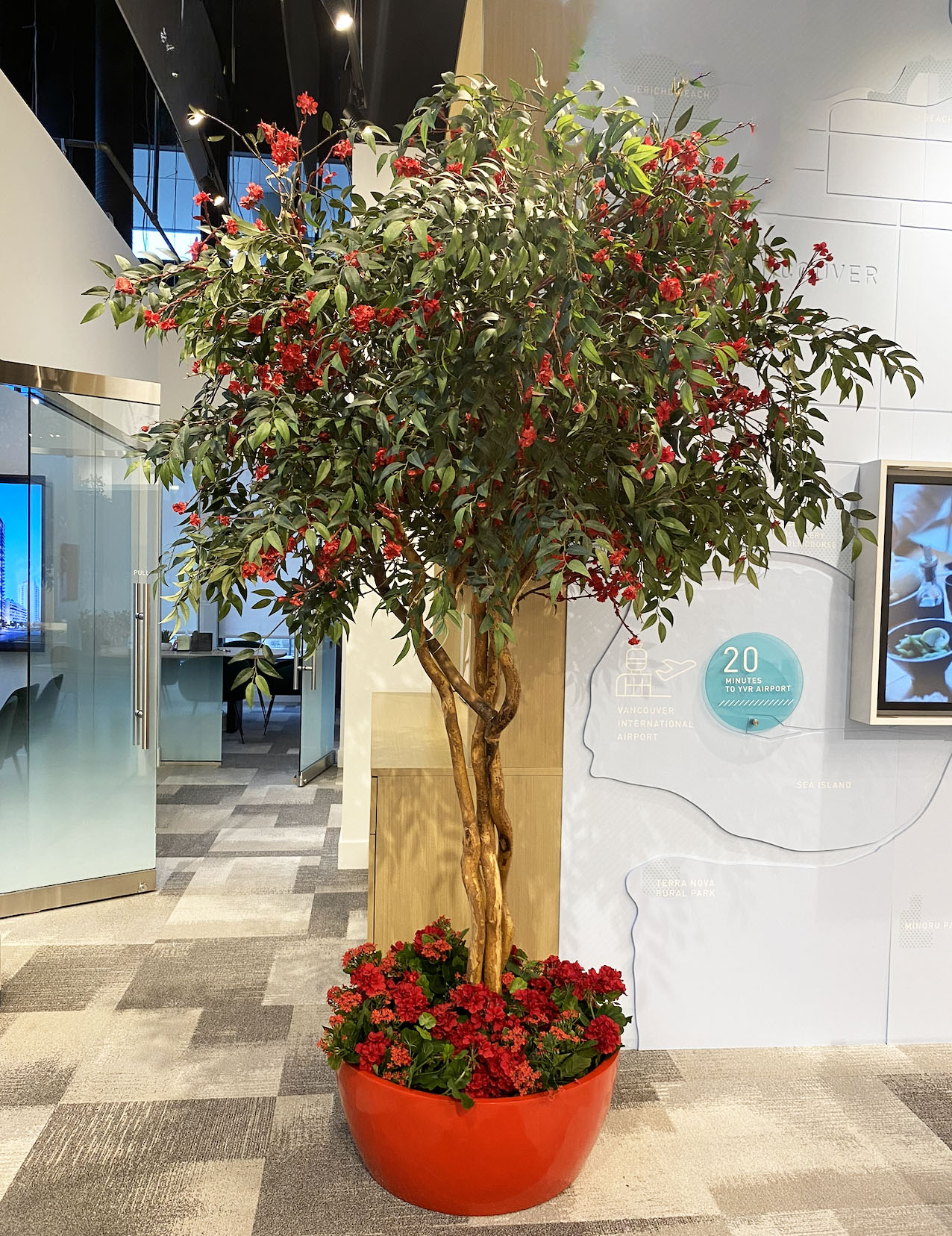 Cherry blossom tree display with red blossoms in commercial space interior