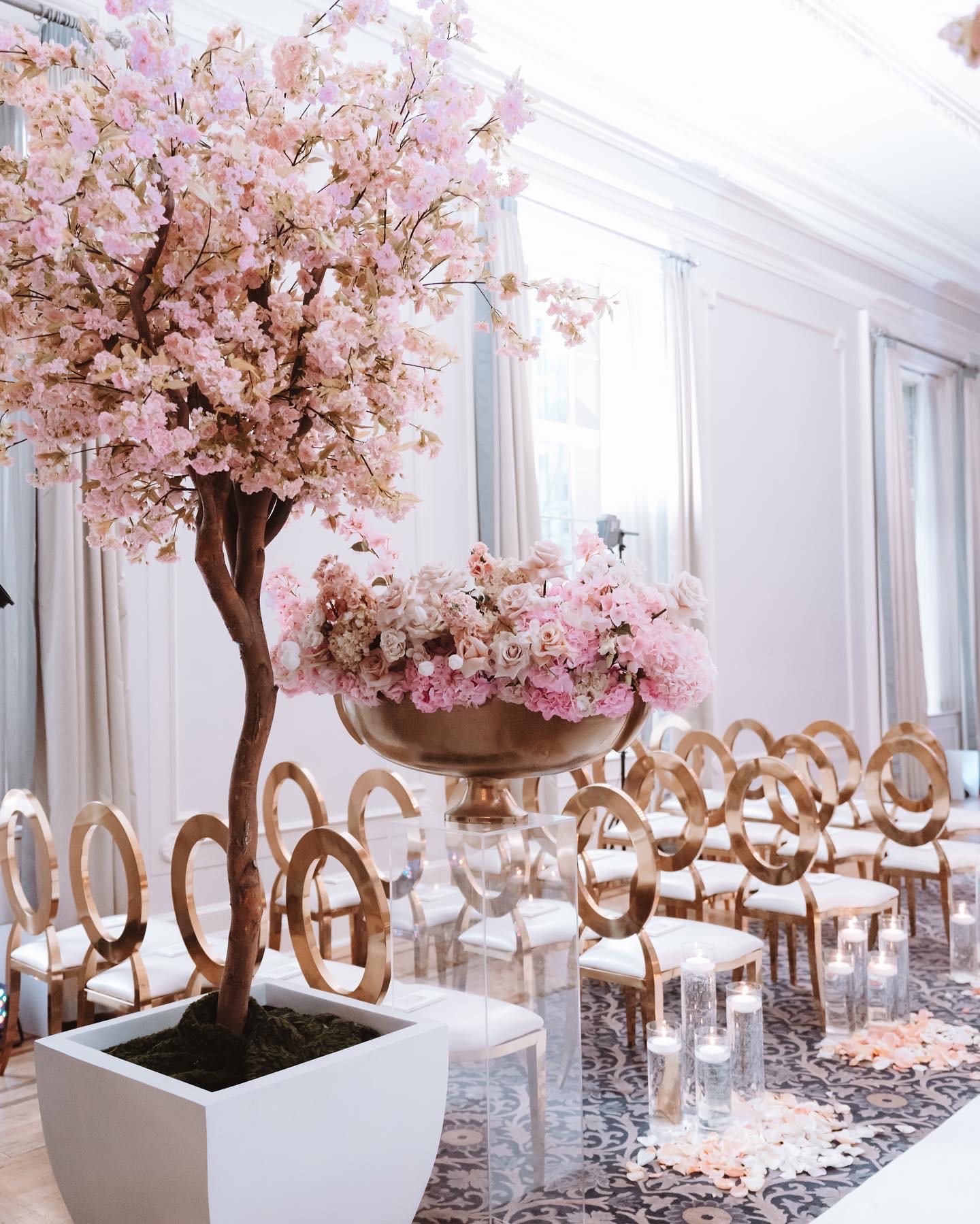 Faux cherry blossom tree in a white planter used as wedding ceremony d&eacute;cor