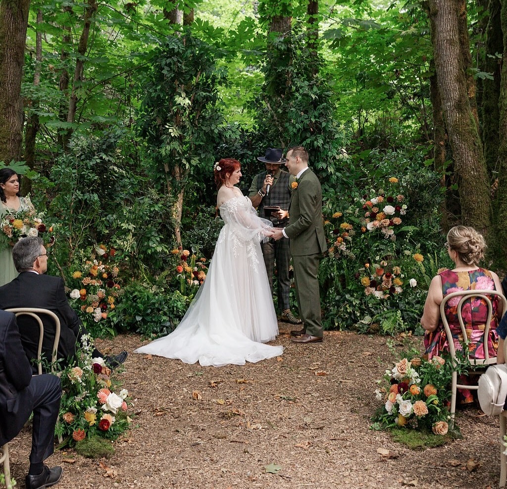 Outdoor forest wedding ceremony with greenery and birch trees