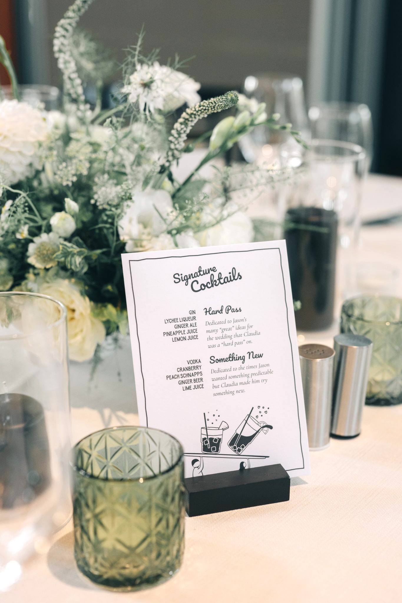 Green and white wedding table with floral centrepiece and cocktail sign