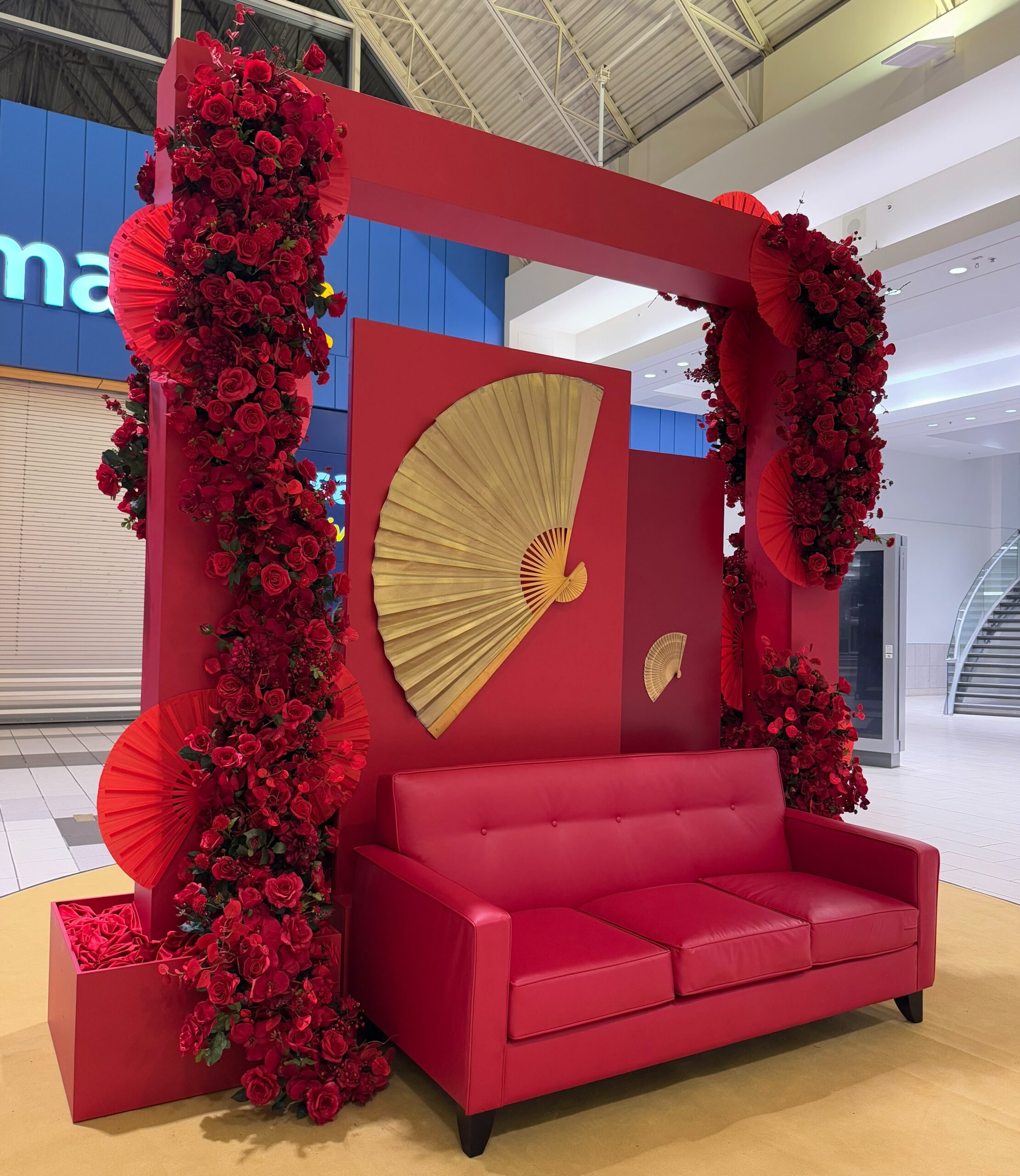 Lunar New Year photo backdrop with red arch and decorative fan in shopping mall