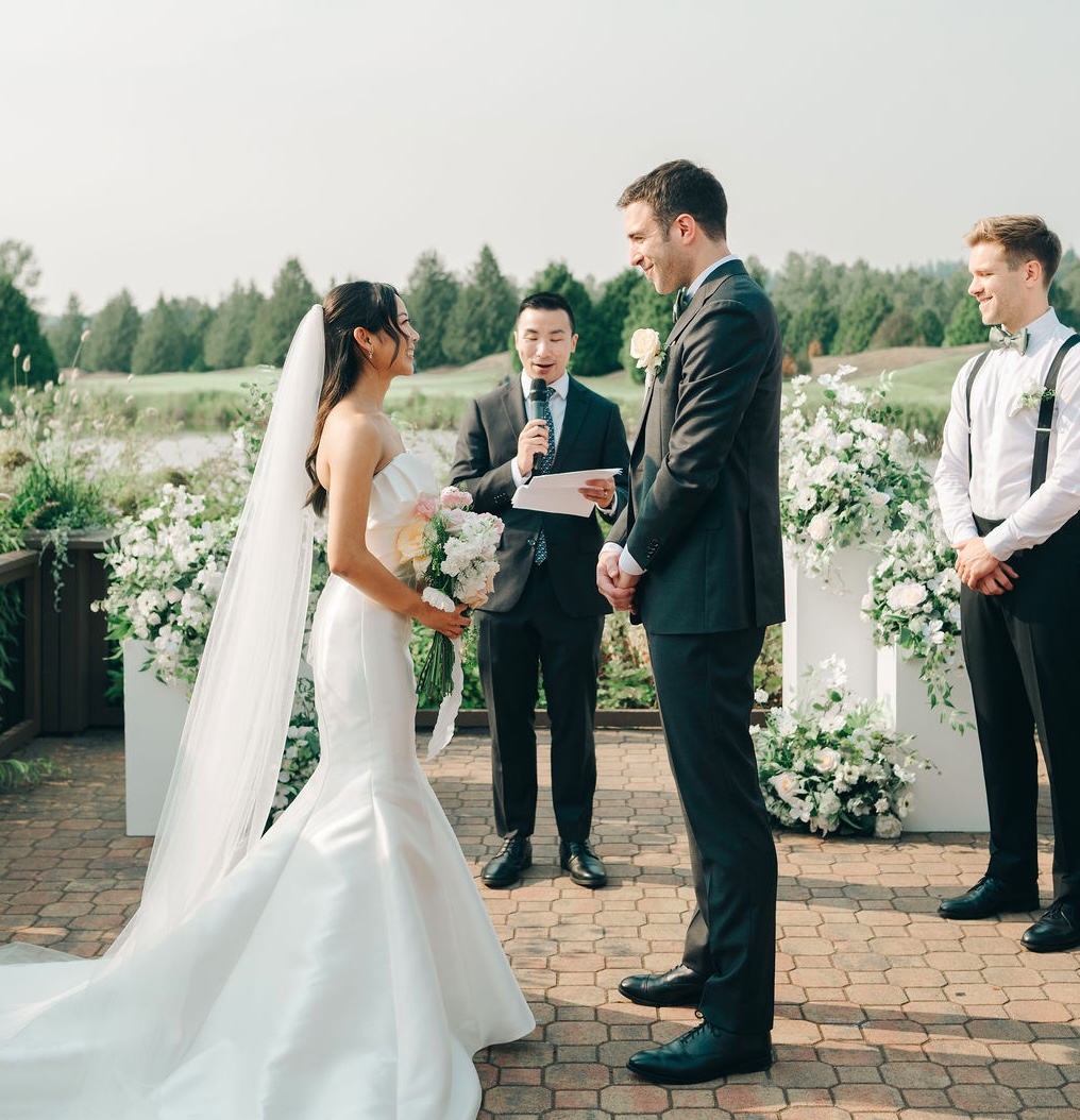 Outdoor wedding ceremony at altar with white floral arrangements