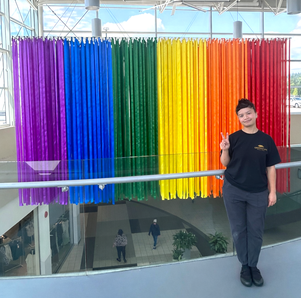 Rainbow ribbon installation hanging in shopping centre atrium for Pride display