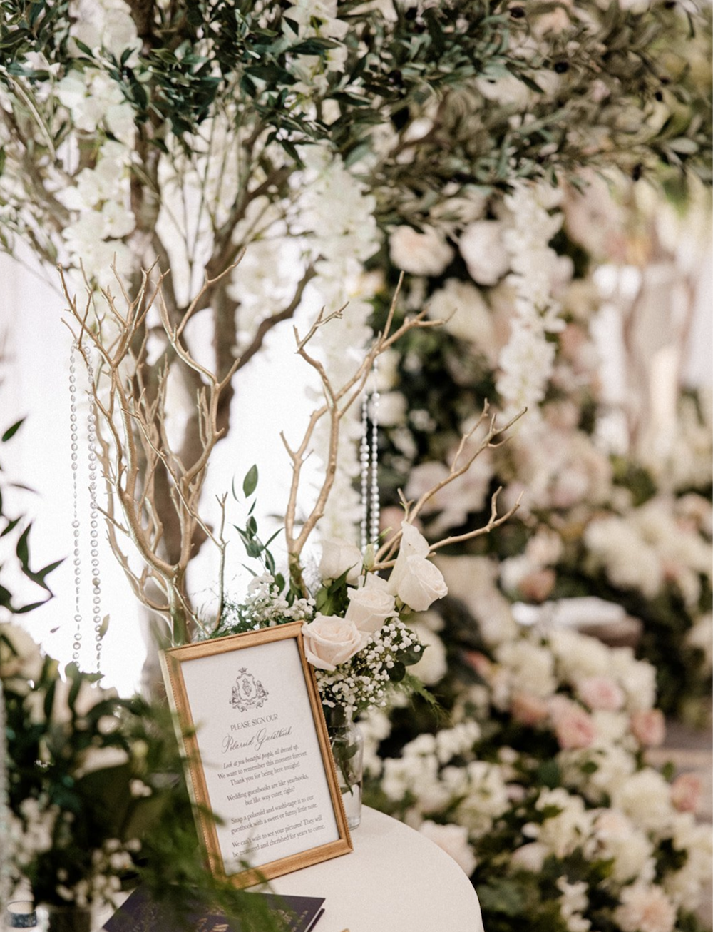 Wedding reception entry table with floral d&eacute;cor and a signage